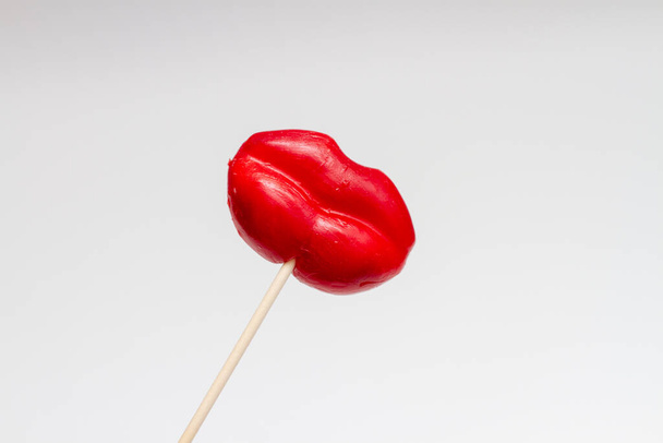 Red Lips Lollipop. Lollipop candy in the shape of red lips on white background. Valentine concept. - Foto, afbeelding