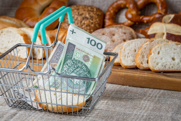 A basket with Polish money, around food products, bread and pastries. The concept of inflation, rising prices and more expensive food  - Fotó, kép