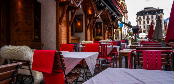 Typical view of the Alpine town street with tables and chairs of cafe in France. Architecture and landmark. View of old cozy street in alpine village. - Valokuva, kuva