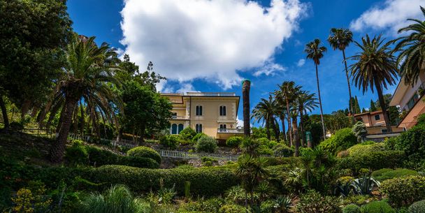 Morning view of Liguria coastline of mediterranean sea. Luxury villa in stunning botanical garden with mediterranean plants. Italy, Europe. Cloudy blue sky sunny day idyllic scenery. - Fotó, kép