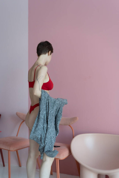 молодая красивая женщина позирует в красном белье в студии - Фото, изображение