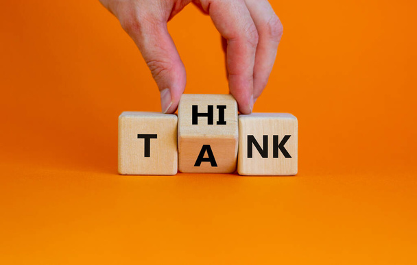Think tank symbol. Businessman turns a wooden cube and changes the word tank to think. Beautiful orange table, orange background, copy space. Business and think tank concept. - Fotoğraf, Görsel