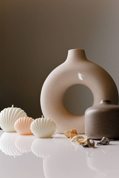 Ceramic pastel design round hole vases with seashell candles and soft aroma grass. Cozy home. Christmas decoration. - Foto, imagen