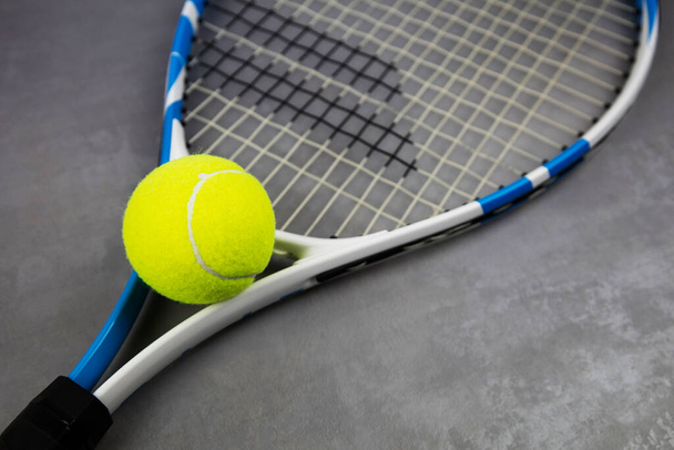 Tennisschläger und Ball auf grauem Hintergrund. Sportspiele. Die Meisterschaft. - Foto, Bild