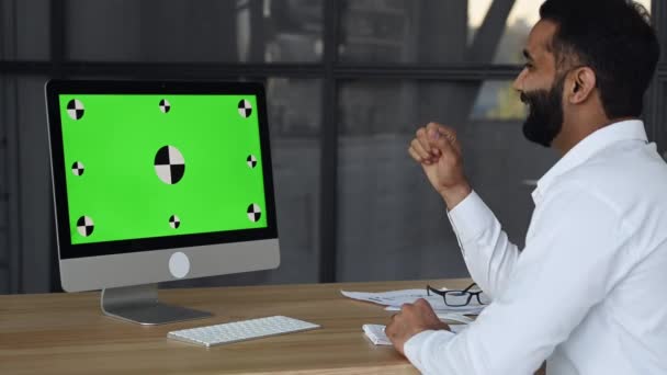 Green computer screen. Indian man having virtual business meeting, talking with successful multi ethnic people via video call, using laptop, sits in office, planning marketing strategy and ideas - Imágenes, Vídeo