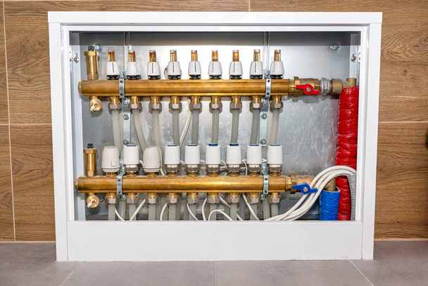 New brass manifold for underfloor heating systems with rotameters and thermoelectric actuators, serving nine circuits. - Foto, imagen