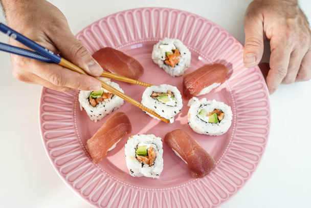 Πιάτο με διάφορα κομμάτια σούσι. - Φωτογραφία, εικόνα