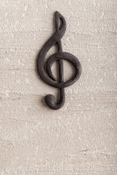 Volumetrikus fekete tripla clef durva felületen. Zenei koncepció. Zenei szimbólum. G kulcs Függőleges keret. - Fotó, kép