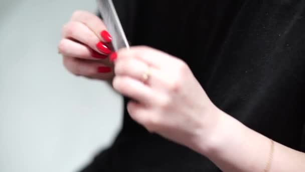 Girl polishes her nails with a nail file. - Video