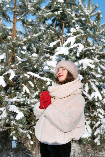 Young woman near snow-covered trees. Vertical frame - Φωτογραφία, εικόνα