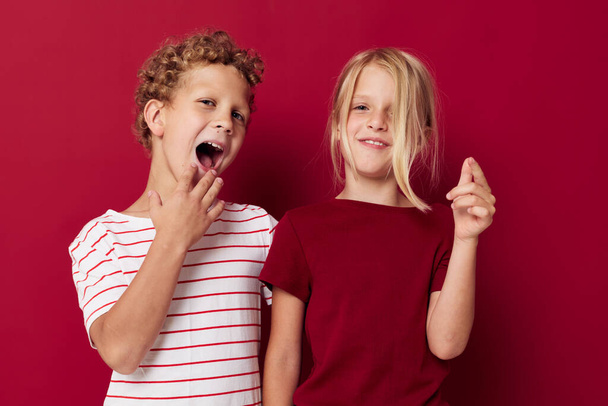 Χαριτωμένο κομψό παιδιά διασκέδαση παιδική διασκέδαση κόκκινο φόντο - Φωτογραφία, εικόνα
