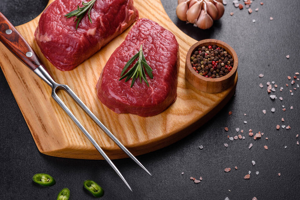 Syrové hovězí steaky na řezací desce s kořením na kamenném pozadí - Fotografie, Obrázek