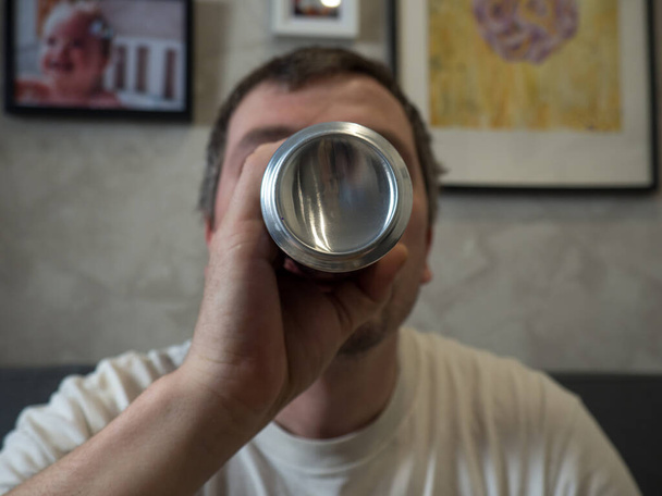 хлопець п'є консервоване пиво вдома на дивані спосіб життя
 - Фото, зображення