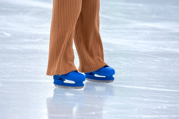 Ice skating on an ice rink. legs with skates. Winter active sport and leisure hobby. - 写真・画像