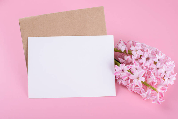 Blank wedding invitation stationery card mockup with envelope on pink background with hyacinth flowers - Photo, Image