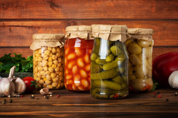 homemade canned vegetables on wooden background - Foto, afbeelding