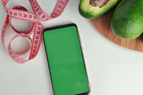 Smartphone avec écran vert et légumes frais copier l'espace. Photo de haute qualité - Photo, image