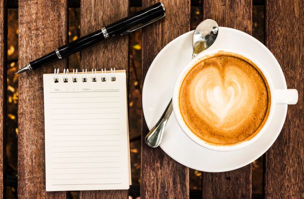 Abra um caderno branco em branco, caneta e xícara de café na mesa de madeira
  - Foto, Imagem