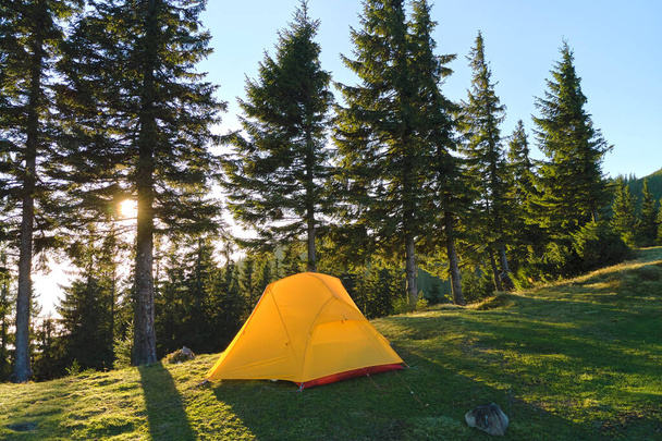 Tourist camping tent on mountain campsite at bright sunny evening. Active tourism and hiking concept - Fotó, kép