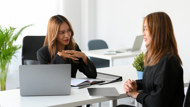 An attractive female manager interviews her work candidate in the office. Human resources interview an applicant. Job interview concept. - Foto, imagen