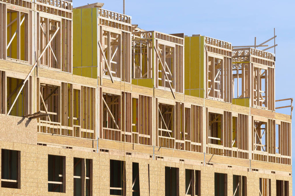 New apartment building under construction on sunny day plywood frame facade - Photo, image
