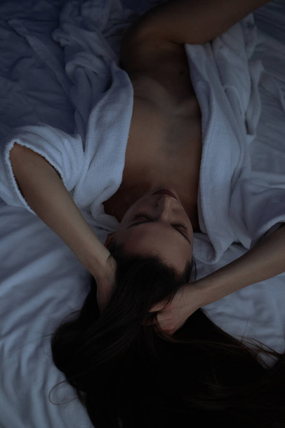 上から上へトップレスセクシー女性でバスローブ嘘で快適なベッドでベッドルーム - 写真・画像