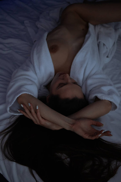 上から上へトップレスセクシー女性でバスローブ嘘で快適なベッドでベッドルーム - 写真・画像