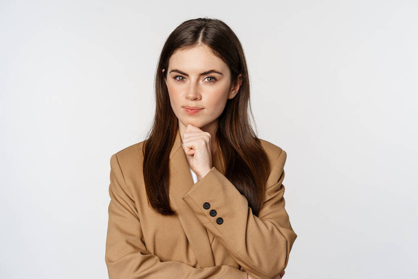 Εικόνα της επιχειρηματικής σκέψης, εταιρική γυναίκα αναζητούν στοχαστική, λήψη απόφασης, στέκεται σε καφέ κοστούμι πάνω από λευκό φόντο - Φωτογραφία, εικόνα
