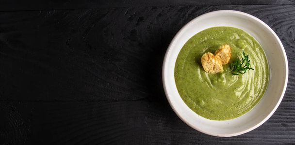 brokkoli leves tál fa háttér. Vega levespüré zöld zöldségekből. Vegetáriánus és diétás ételek. - Fotó, kép