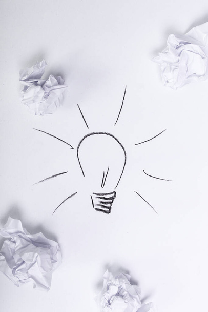 Crumpled paper with light bulb drawning on a white background - Foto, Bild