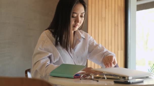Ασιάτισσα ελεύθερη επαγγελματίας που εργάζεται σε καφετέρια - Πλάνα, βίντεο