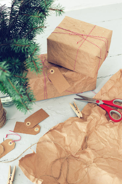 Regalos de Navidad envueltos en papel artesanal en el suelo - Foto, imagen