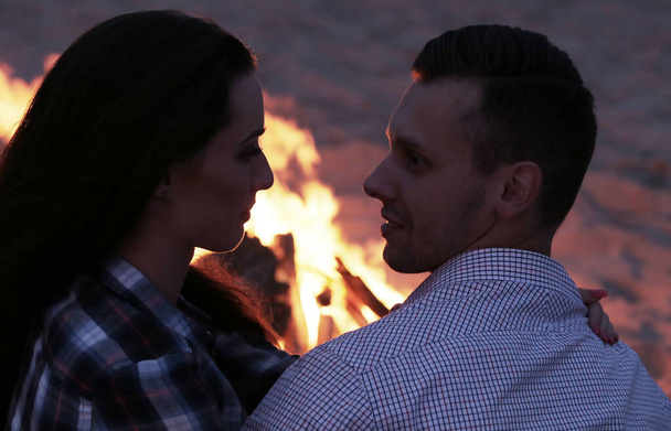 Beautiful couple near bonfire on the beach - Zdjęcie, obraz