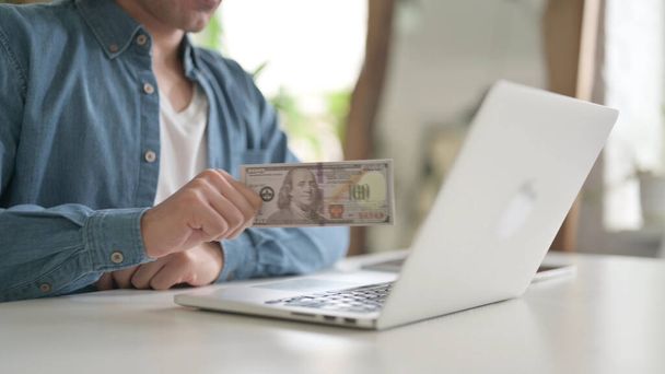 Close Up of Man Investing Dollars Through Laptop - Foto, imagen