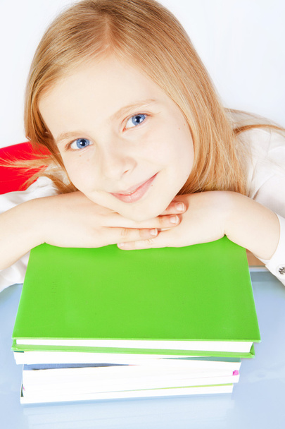 Smiling small girl with books on table - Foto, imagen