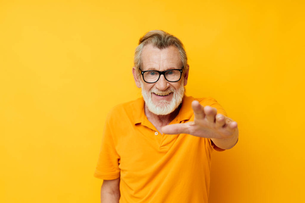 Portrait of happy senior man posing yellow tshirt glasses cropped view - Фото, изображение