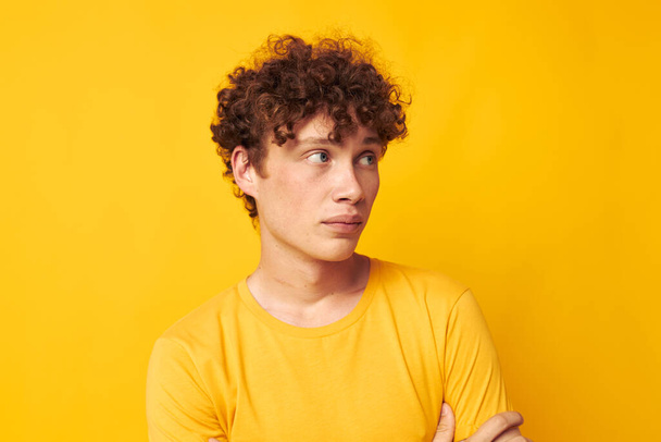 Young curly-haired man Youth style studio casual wear yellow background unaltered - Φωτογραφία, εικόνα