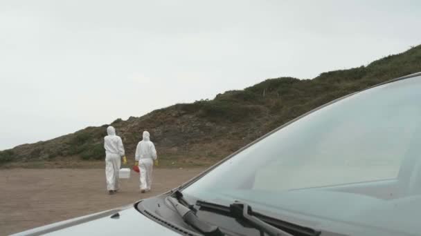 Unrecognizable scientists with bacteriological equipment walking outdoors - Materiaali, video