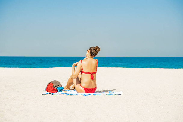 Péče o pleť. Ochrana před sluncem. Žena nanáší opalovací krém. Žena s opalovacím krémem na pláži. Opalovací krém. Dívka drží hydratační opalovací krém - Fotografie, Obrázek