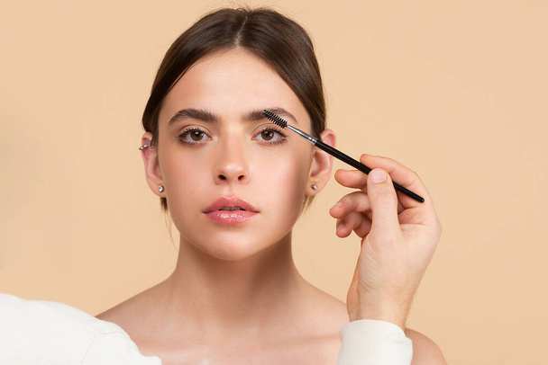 Woman eye with beautiful eyebrows. Perfect shaped brow, eyelashes with brow gel brush. Female model shaping brown eyebrows. - Фото, зображення