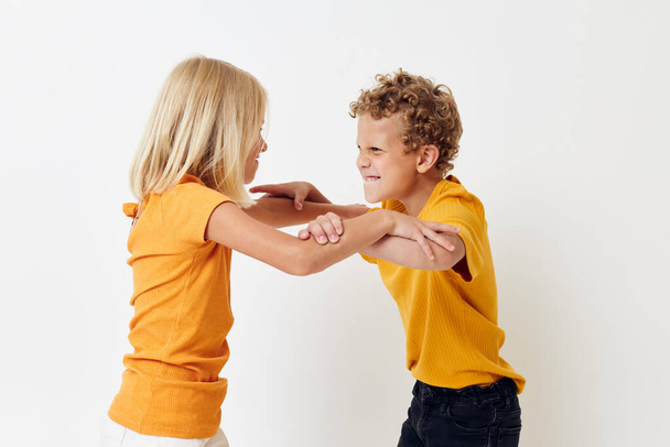 Portrait of cute children in yellow t-shirts standing side by side childhood emotions unaltered - Foto, afbeelding