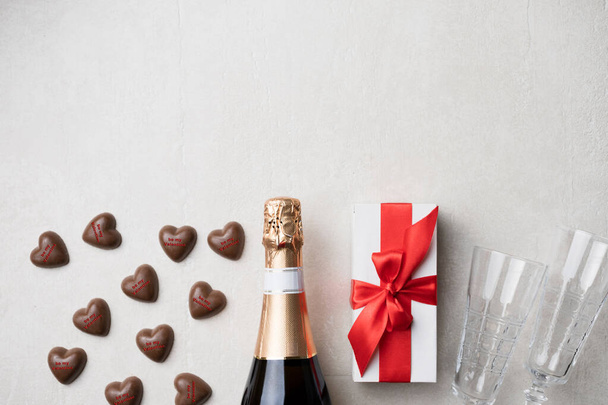 chocolate hearts with inscription be my valentine and champagne with gift and champagne glasses, free space for text, top view - Photo, Image