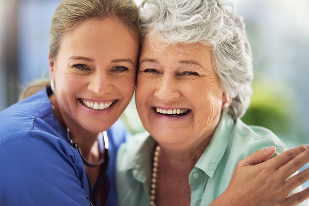 Portrait of a smiling nurse with her senior patient in a hospital - Fotó, kép