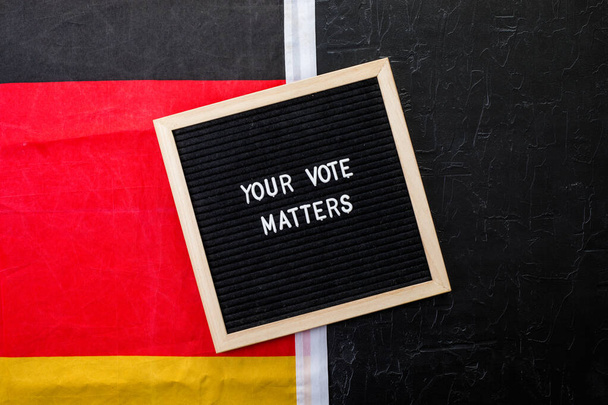 Letterboard sign with the words your vote matters with German flag on  black background - Photo, image