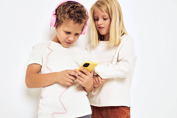 Portrait of his he her smiling with phone in hand fashion lifestyle childhood - Foto, Bild