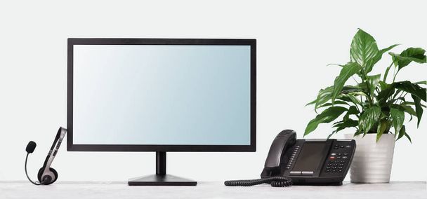 Computer monitor VOIP headset phone on desk at modern office. Telecommunications - Foto, imagen