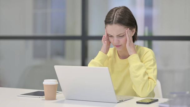 Dizüstü bilgisayarda çalışırken baş ağrısı olan genç kadın - Fotoğraf, Görsel
