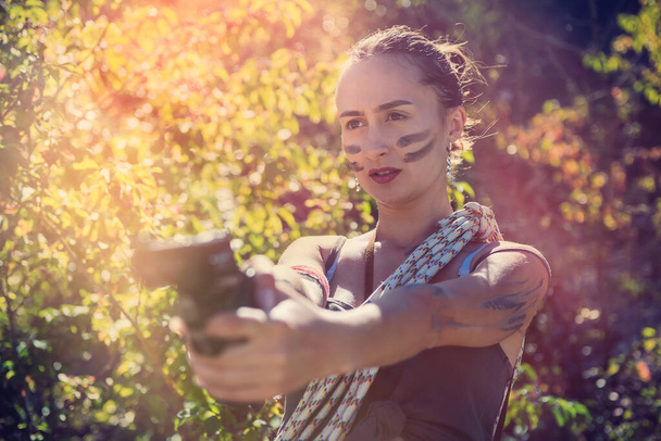 Szexi női modell visel rövid ruha pisztollyal nyáron szabadban, hadsereg koncepció - Fotó, kép