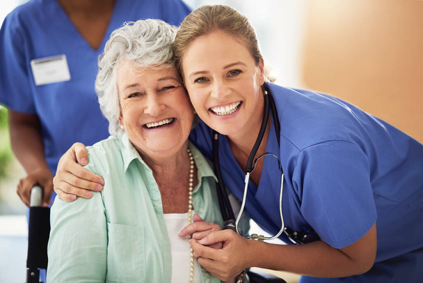 Retrato de una enfermera sonriente con su paciente mayor en un hospital - Foto, Imagen