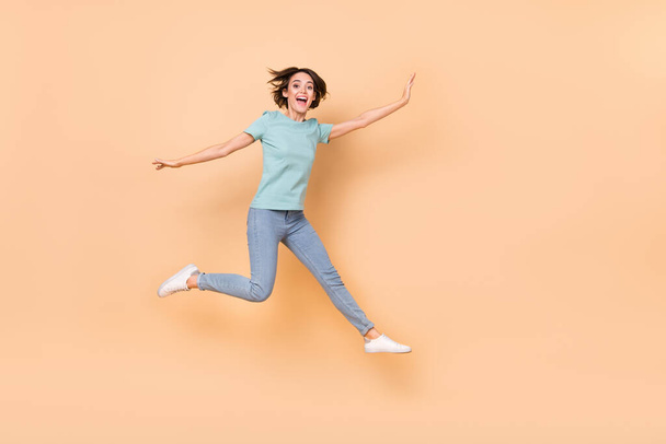 Full length photo of young cheerful lady jumper wear casual outfit isolated over beige color background. - Фото, зображення